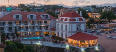 Cascais 'in hava panoramik günbatımı görüntüsü. Lizbon 'un 30 km batısında Portekiz' in Cascais bölgesinde. Praia da Rainha 'nın havadan görünüşü ve tarihi şehir merkezi Cascais, Portekiz