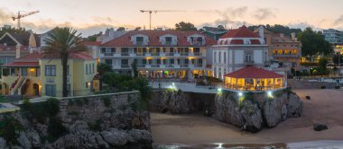 Cascais 'in hava panoramik günbatımı görüntüsü. Lizbon 'un 30 km batısında Portekiz' in Cascais bölgesinde. Praia da Rainha 'nın havadan görünüşü ve tarihi şehir merkezi Cascais, Portekiz