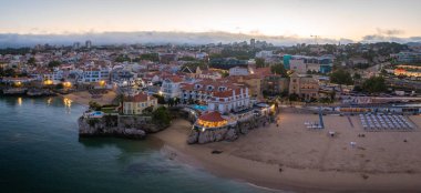 Cascais 'in hava panoramik günbatımı görüntüsü. Lizbon 'un 30 km batısında Portekiz' in Cascais bölgesinde. Praia da Rainha 'nın havadan görünüşü ve tarihi şehir merkezi Cascais, Portekiz