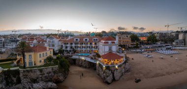 Cascais 'in hava panoramik günbatımı görüntüsü. Lizbon 'un 30 km batısında Portekiz' in Cascais bölgesinde. Praia da Rainha 'nın havadan görünüşü ve tarihi şehir merkezi Cascais, Portekiz