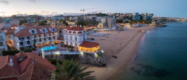 Cascais 'in hava panoramik günbatımı görüntüsü. Lizbon 'un 30 km batısında Portekiz' in Cascais bölgesinde. Praia da Rainha 'nın havadan görünüşü ve tarihi şehir merkezi Cascais, Portekiz
