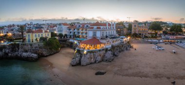 Cascais 'in hava panoramik günbatımı görüntüsü. Lizbon 'un 30 km batısında Portekiz' in Cascais bölgesinde. Praia da Rainha 'nın havadan görünüşü ve tarihi şehir merkezi Cascais, Portekiz