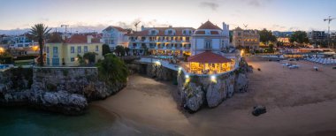 Cascais 'in hava panoramik günbatımı görüntüsü. Lizbon 'un 30 km batısında Portekiz' in Cascais bölgesinde. Praia da Rainha 'nın havadan görünüşü ve tarihi şehir merkezi Cascais, Portekiz