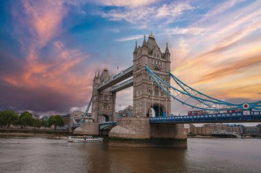 İngiltere, Londra 'daki Iconic Tower Köprüsü' nde gün batımında altından bir tekne geçiyordu. Gökyüzü turuncu, pembe ve mavi renkleri tarihi yapıyı geliştirir..