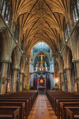 Çarpıcı Gotik mimari, tırtıklı kubbe, kemerli pencereler, süslü sunaklar, ve tarihi Cambridge kilisesinde canlı vitray..