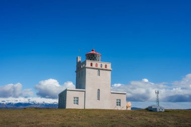 Dyrholaey Deniz Feneri İzlanda 'nın güney kıyısında yer alır. Çimen tarlaları, kamu hizmetleri binası ve iletişim kulesi ile çevrilidir..