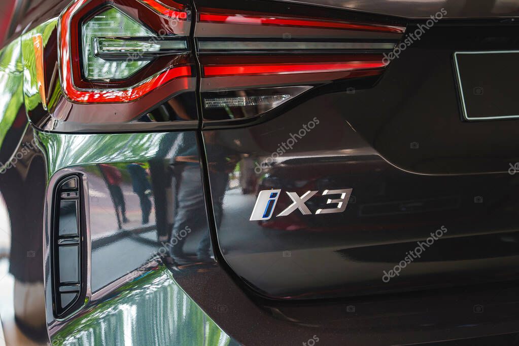 Sleek and modern design of the black BMW iX3 luxury electric SUV with distinctive taillights and model badge, parked indoors in a London showroom.