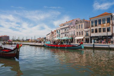 Renkli geleneksel binalar ve süslü cepheler Portekiz 'in Aveiro şehrindeki kanal boyunca uzanır. Moliceiros 'lar su kenarına yanaştı ve gezinti güvertesine cazibe kattı..