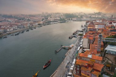 Porto, Portekiz 'in çarpıcı hava manzarası, Douro Nehri, geleneksel tekneler, Ribeira bölgesi, ve gün batımında ikonik Dom Luis Köprüsü..