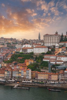 Porto, Portekiz 'in çarpıcı manzarası, terakotta çatılı binalar, Clerigos Kulesi ve Douro Nehri. Şehir batan güneşin ılık renkleriyle yıkanır..