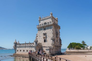 Portekiz 'in Lizbon kentindeki UNESCO Dünya Mirasları Bölgesi olan ikonik Belem Kulesi, Tagus Nehri kıyısında yer alıyor. Turistler tarihi yerleri keşfediyorlar..