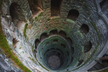 Portekiz 'in Sintra kentindeki Quinta da Regaleira' daki Kabul Kuyusu 'nda ezoterik sembolizmini gözler önüne seren yosun kaplı taş duvarlara inen sarmal bir merdiven bulunmaktadır..