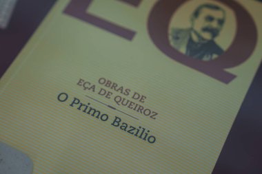 Eca de Queiroz 'un O Primo Bazilio' nun sarı çizgili kapağında yazarın portresi yer almaktadır. Obras de Eca de Queiroz koleksiyonunun bir parçası.