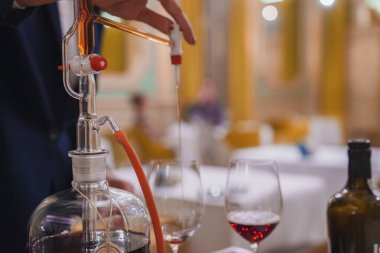 A sophisticated wine decanting process in a high-end hotel dining setting. The scene features opulent decor, golden hues, and meticulous attention to detail. clipart