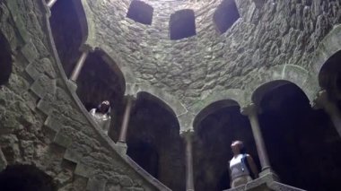 Portekiz 'in Sintra kentindeki Quinta da Regaleira' daki Kabul Kuyusu 'nda ezoterik sembolizmini gözler önüne seren yosun kaplı taş duvarlara inen sarmal bir merdiven bulunmaktadır..