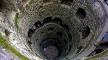 Portekiz 'in Sintra kentindeki Quinta da Regaleira' daki Kabul Kuyusu 'nda ezoterik sembolizmini gözler önüne seren yosun kaplı taş duvarlara inen sarmal bir merdiven bulunmaktadır..