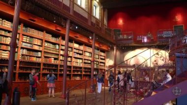 Porto 'da tarihi bir kütüphanede kitap dolu entrika ile oyulmuş ahşap kitaplıklar. Yuvarlanan bir merdiven, zengin ambiyansı artırmak için yüksek hacimlere erişim sağlar..