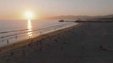 Kaliforniya, Los Angeles 'taki Santa Monica İskelesi' nin gün batımında havadan görüntüsü. Santa Monica İskelesi 'nde güzel bir yaz manzarası. Dönme dolap, lunapark treni, lunapark gezileri ve oyunlar.