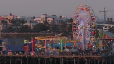 Kaliforniya, Los Angeles 'taki Santa Monica İskelesi' nin gün batımında havadan görüntüsü. Santa Monica İskelesi 'nde güzel bir yaz manzarası. Dönme dolap, lunapark treni, lunapark gezileri ve oyunlar.