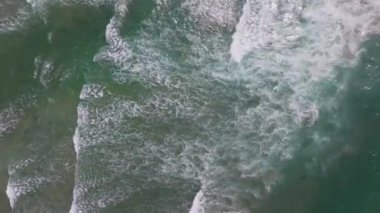 Okyanusun güçlü, çarpıcı bir dalgası, aşağıdaki derin sulara doğru beyaz bir püskürtüye dönüşen dalganın hayranlık ve güç hissini uyandırdığı bu çarpıcı hava görüntüsünde yer alıyor..