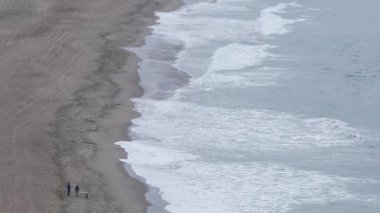 Okyanusun güçlü, çarpıcı bir dalgası, aşağıdaki derin sulara doğru beyaz bir püskürtüye dönüşen dalganın hayranlık ve güç hissini uyandırdığı bu çarpıcı hava görüntüsünde yer alıyor..