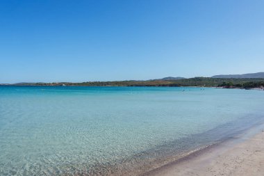 Kristal berrak suları, kumlu kıyıları ve parlak mavi gökyüzünün altındaki tepelerin manzaralı zeminiyle el değmemiş Sardunya sahillerinde sükuneti hissedin..