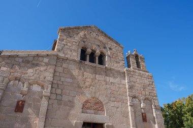 Sardunya, Olbia 'daki San Simplicio Kilisesi' nin Romanca mimarisini araştırın. Granit bloklar, kemerli pencereler ve çan kulesi huzur verici bir sahne oluşturur..