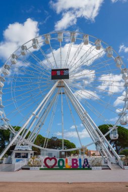 Sardinya, Olbia 'da mavi gökyüzüne karşı duran ikonik dönme dolabı deneyin. Renkli OLBIA işareti ve yemyeşil hoş geldin sahnesi yarattı..
