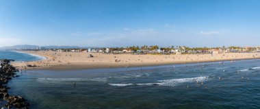 Los Angeles, Kaliforniya 'daki Venedik Sahili' nin panoramik hava manzarası, kumlu kıyılar, Pasifik Okyanusu dalgaları, palmiye ağaçları ve sahil binaları.