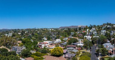 Havadan bakıldığında Hollywood, Los Angeles 'ta çeşitli evleri ve yemyeşil yeşillikleri olan bir yerleşim yeri görülüyor. Hollywood Tepeleri arka planda görünür..