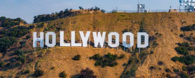 Hollywood tabelası Los Angeles, Kaliforniya 'daki Lee Dağı' nda sergileniyor. Arka planda iletişim kuleleri ve açık bir gökyüzü var..