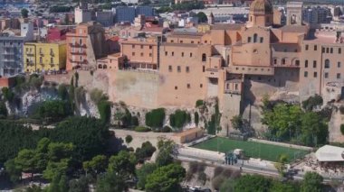 Cagliaris Castello ilçesinde ortaçağ mimarisi, Bastione di Saint Remy ve Akdeniz ve uzak dağlarla çevrili bir şehir manzarası bulunur..