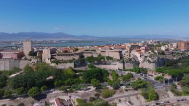 Cagliaris Castello ilçesinde ortaçağ mimarisi, Bastione di Saint Remy ve Akdeniz ve uzak dağlarla çevrili bir şehir manzarası bulunur..