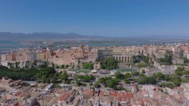 Cagliaris Castello ilçesinde ortaçağ mimarisi, Bastione di Saint Remy ve Akdeniz ve uzak dağlarla çevrili bir şehir manzarası bulunur..