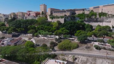Cagliaris Castello ilçesinde ortaçağ mimarisi, Bastione di Saint Remy ve Akdeniz ve uzak dağlarla çevrili bir şehir manzarası bulunur..