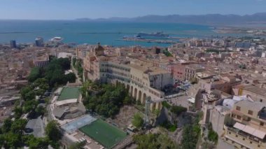 Cagliaris Castello ilçesinde ortaçağ mimarisi, Bastione di Saint Remy ve Akdeniz ve uzak dağlarla çevrili bir şehir manzarası bulunur..