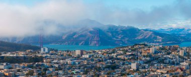 San Francisco 'nun sisli Golden Gate Köprüsü, yoğun şehir manzarası ve arka planda Marin County tepeleri ile hava görüntüsü..