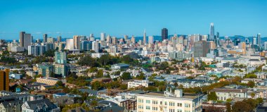 Görüntü San Franciscos siluetini yakalıyor, Transamerica Piramidi ve Satış Gücü Kulesi 'ni açık mavi gökyüzü altında çeşitli mimariler arasında vurguluyor..