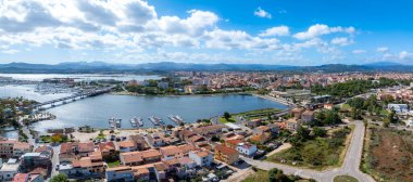 Olbia, Sardinya 'nın havadan görünüşü, tekneleri, terracotta çatısı olan bir marinayı, birbirine bağlı bir köprüyü ve modern ve geleneksel mimarinin bir karışımını gösteriyor..