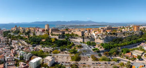 Görüntü, Cagliaris Castello bölgesini antik tahkimatları ve renkli binalarıyla, Cagliari Körfezi 'ne ve uzak dağlara karşı ele geçiriyor..