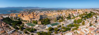 Tarihi Castello bölgesinin, renkli binaların, yemyeşil otlakların ve yolcu gemileriyle dolu hareketli bir limanın yer aldığı Cagliari, Sardinya 'nın hava manzarası..