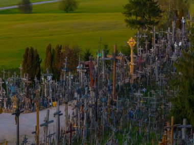 Litvanya 'daki Haçlar Tepesi' nde, ağaçlı ve patikalı yemyeşil bir arazide yer alan çeşitli boyut ve malzemelerden oluşan binlerce haç yer alıyor..