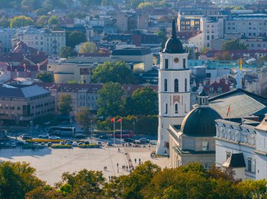 Vilnius Katedrali ve çan kulesi, aşağıdaki meydanda insanların bulunduğu tarihi ve modern binaların bir karışımıyla çevrilidir..