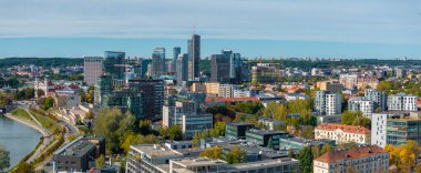 Vilnius, Litvanya 'nın hava perspektifi, modern yüksek binalar, geleneksel mimari, Neris Nehri ve berrak bir gökyüzü altında yemyeşil.