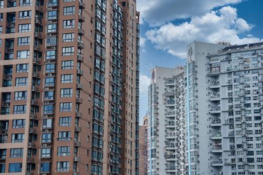 View of modern high rise residential buildings in Shanghai, China, featuring diverse architectural styles and a partly cloudy sky. clipart