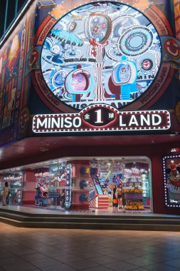 Görüntü, MINISO LAND 'ın Şangay' daki canlı dış görüntüsünü yakalıyor. Girişte büyük dairesel bir ekran, parlak ışıklar ve oyuncu grafikler var..