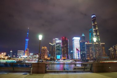 Shanghais gökdeleninde aydınlık Doğu İnci Kulesi ve Şangay Kulesi yer alır. Huangpu Nehri 'ndeki yansımalar görülebilir..