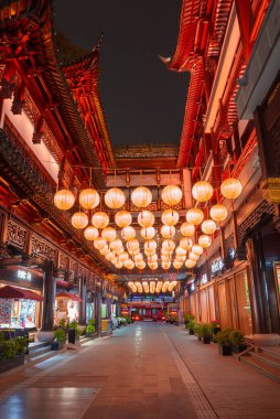 Shanghais 'in eski bir kasabasında, geleneksel Çin mimarisine ev sahipliği yapan bir cadde. Ahşap oymalar ve kırmızı kiremitli çatılar, asılı fenerlerle aydınlatılmış..