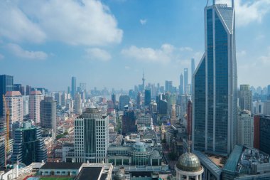 Shanghais gökdelenlerinin ve gökdelenlerin ortasındaki Doğu İnci Kulesi 'nin ve açık mavi gökyüzünün altındaki tarihi binaların yer aldığı gökyüzü manzarası..
