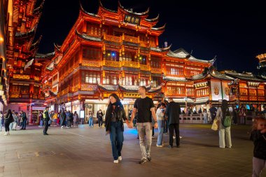 Şangay 'daki Yuyuan Eski Caddesi geceleri canlı, geleneksel Çin mimarisi aydınlatılıyor. İnsanlar caddeyi dolduruyor, canlı atmosferi arttırıyor..